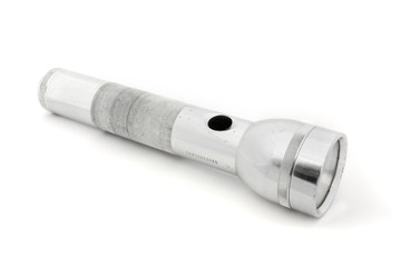 Silver flashlight over white