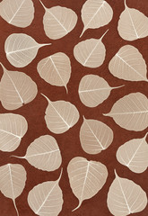 Skeletal leaves over brown handmade paper - background