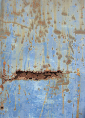 slate of grungy blue metal with rusty holes
