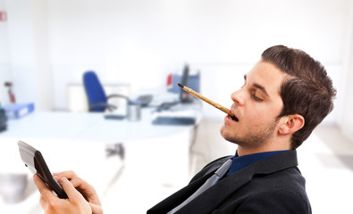 Businessman working with calculator with a pen in his mouth