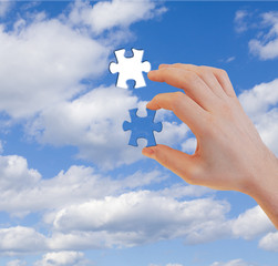 Human hand with last puzzle piece