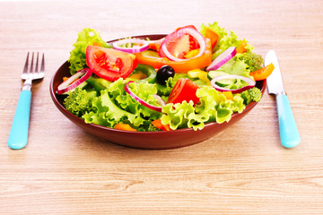 many vegetables on the plate on a wooden background