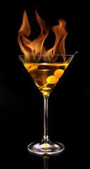 Burning Martini drink isolated on black background