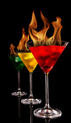 Burning Martini drinks on black background