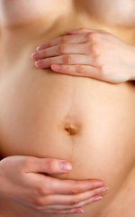 Fototapeta na wymiar Pregnant woman holding abdomen