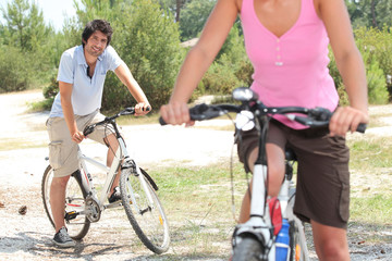 Obraz premium Couple riding bikes in the countryside