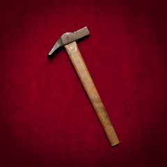 old sledge hammer with wooden handle on a red background