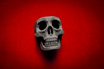 black scary human skull on red velvet background