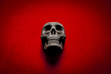 black scary human skull on red velvet background