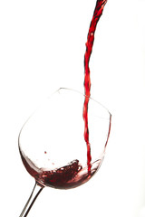 Red wine splash on a glass, white background.