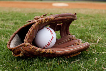 Baseball in Old Glove on Field - 33249584