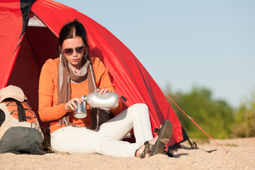 Camping happy woman sitting front of tent