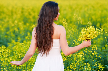 Naklejka na ściany i meble girl with flowers at summer field