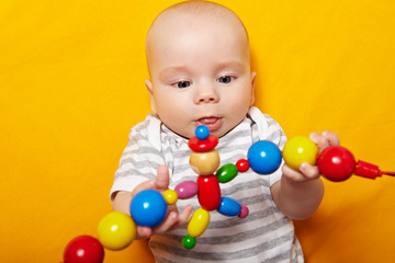 Fototapeta na wymiar Baby greift nach Spielzeugkette