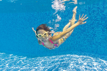 Happy smiling underwater kid in swimming pool