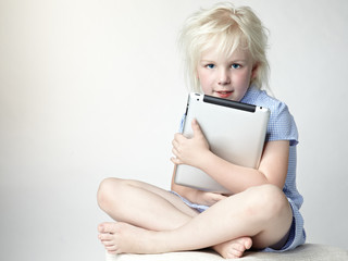 Cute blond girl loves her touchpad so much