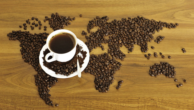 Dramatic photo of world map made of coffee beans. White cup with