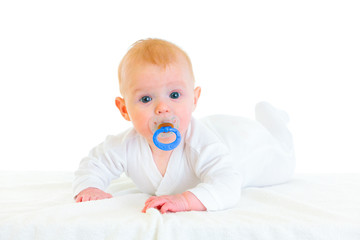 Sweet  four month old  baby girl with soother laying on diaper.