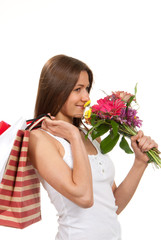 woman holding shopping bags, presents and bouquet of flowers