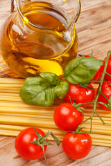 pasta, olive oil and tomatoes on the wood background