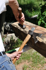 Carpenter with axe and  hand hammer