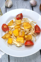 gegrillte gelbe Paprika mit Tomate auf Bandnudeln