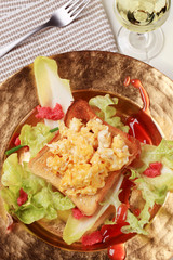 Scrambled eggs on toast and fresh salad
