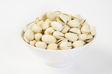 pistachio nuts in a bowl on white background
