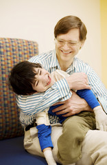 Fototapeta na wymiar Father holding disabled son in doctor's office