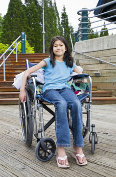 Young girl in wheelchair in front of stairs