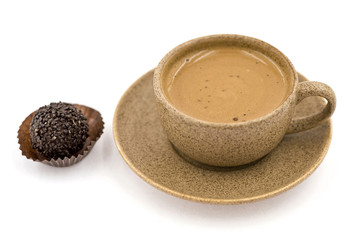 A Cup with Coffee  Beside a Candy on the White Background