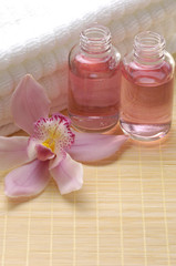 Obraz na płótnie Canvas spa essentials- white towel, orchid flowers and massage lotion