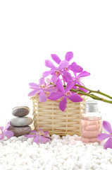 Spa still life with basket of pink orchid on pebble