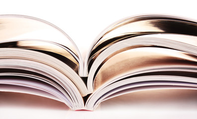 Pile of open magazines isolated on white background
