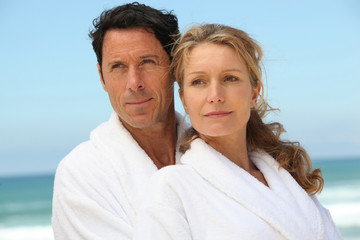Obraz premium Couple on the beach in white dressing downs
