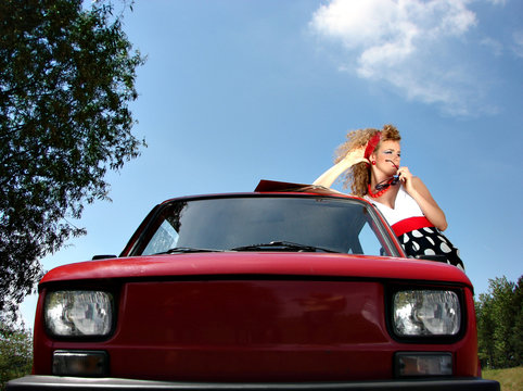 Girl in dress with red comapct car