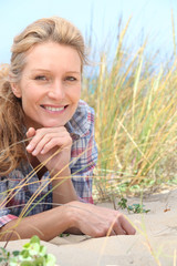 Fototapeta premium Woman laying on the sand