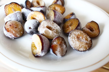 Frozen, defrosting plums on a plate
