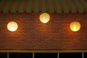 Brick wall with three illuminated lamps