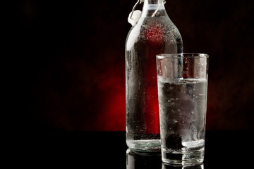 Acqua in bicchiere di vetro con bottiglia