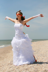 Naklejka premium Bride with bouquet on the beach. Tropical wedding