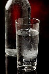 Acqua in bicchiere di vetro con bottiglia
