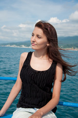 Fototapeta na wymiar A beautiful young woman on a yacht at sea