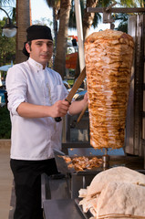 Chef slicing Turkish doner kebab.