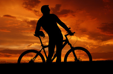 Obraz premium mountain biker silhouette in sunrise