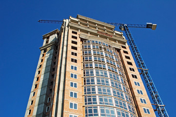 Fototapeta na wymiar Budowa d¼wigu i budynku w trakcie budowy z błękitnego nieba