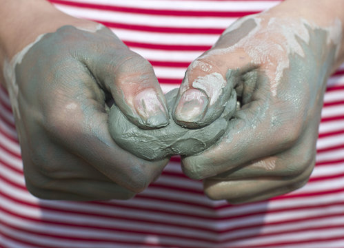 Child Models Handicraft In Lump Of Clay By Hands