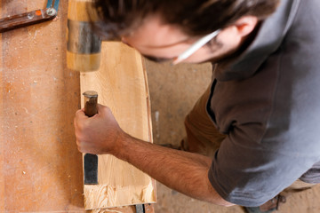 Carpenter with chisel and hammer