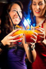 Leute mit Cocktails in Bar oder Club
