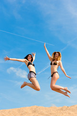 Obraz na płótnie Canvas Zwei glückliche Frauen springen hoch mit Spaß